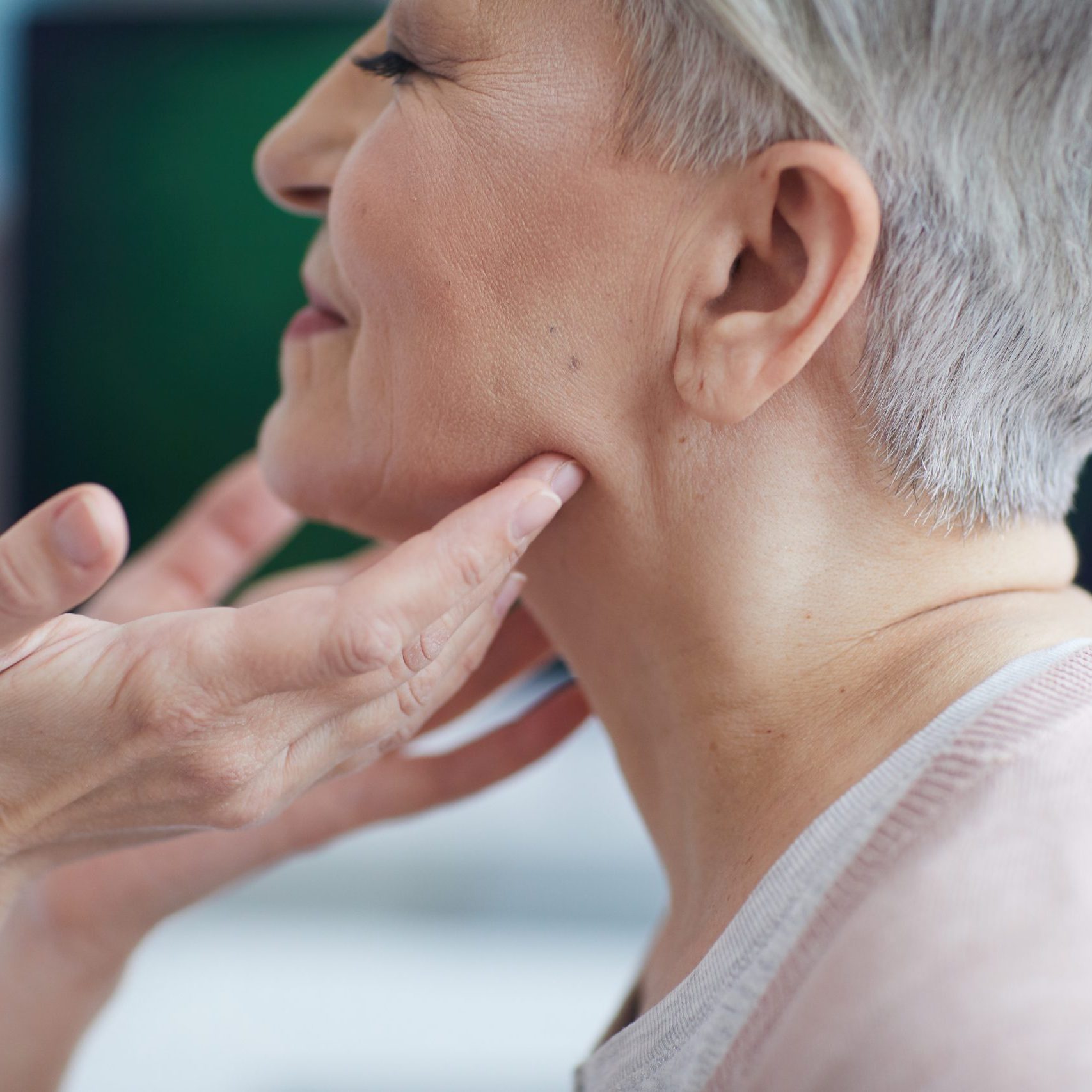 Doctor Examining Neck of Senior Woman