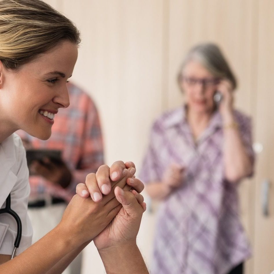 smiling-female-doctor-holding-hands-with-disabled-2023-11-27-05-14-25-utc